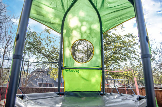 Shaded deck on a green kids climbing tower