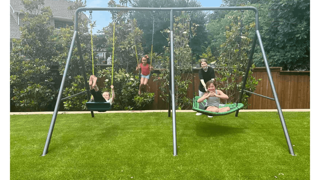 Four kids playing on an anchored swing set.